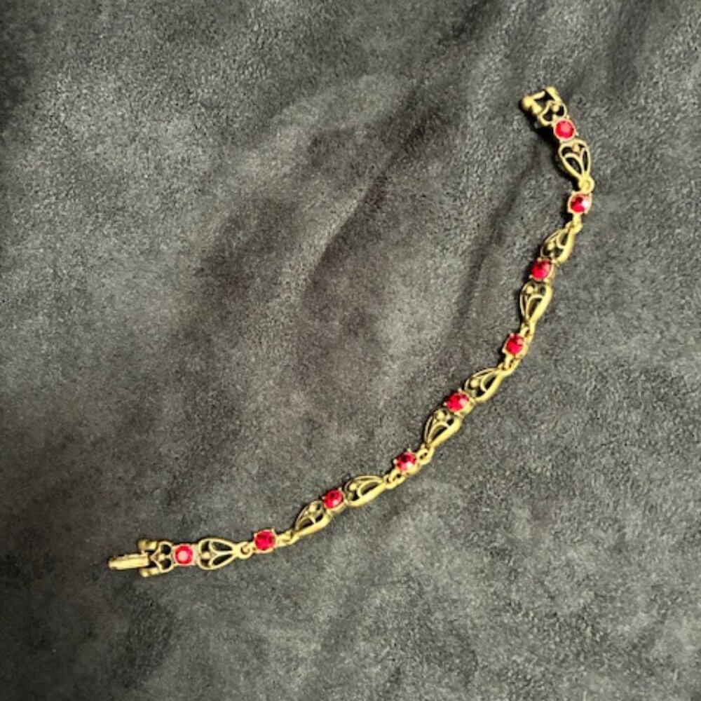 Bracelet with gold tone and garnet stones.